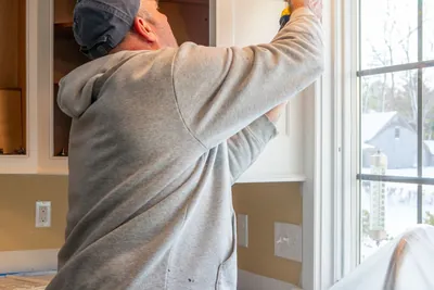 A hand applying a fresh bead of caulk during a renovation